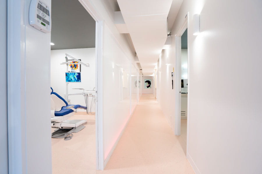 Hallway leading to dental treatment rooms in a modern dental practice.
