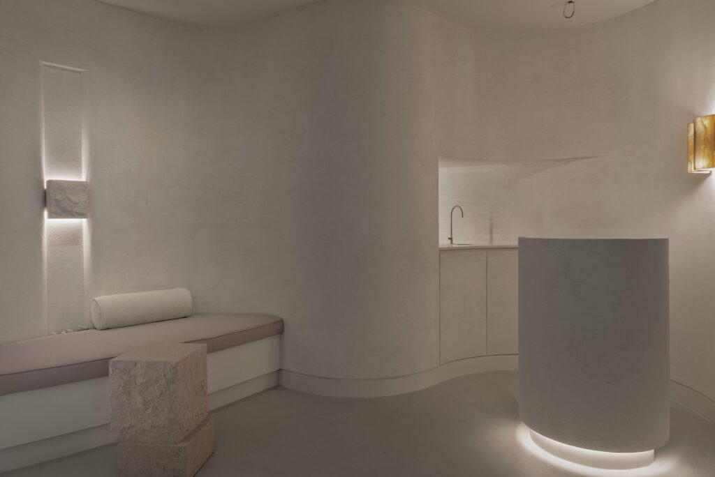Minimalist reception area with curved joinery and soft lighting in a dental clinic