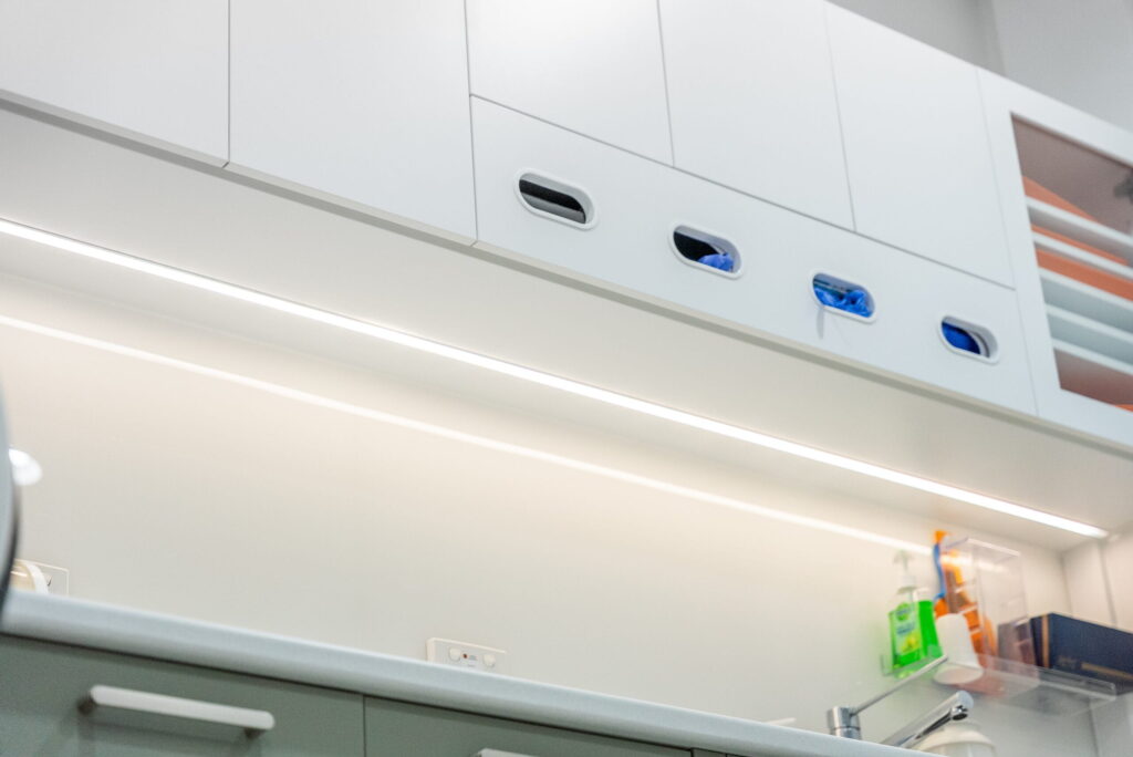 Modern dental surgery design featuring custom overhead cabinetry and integrated storage