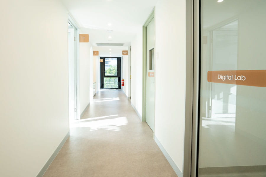 Wide corridor with treatment rooms and a digital lab in a contemporary dental clinic