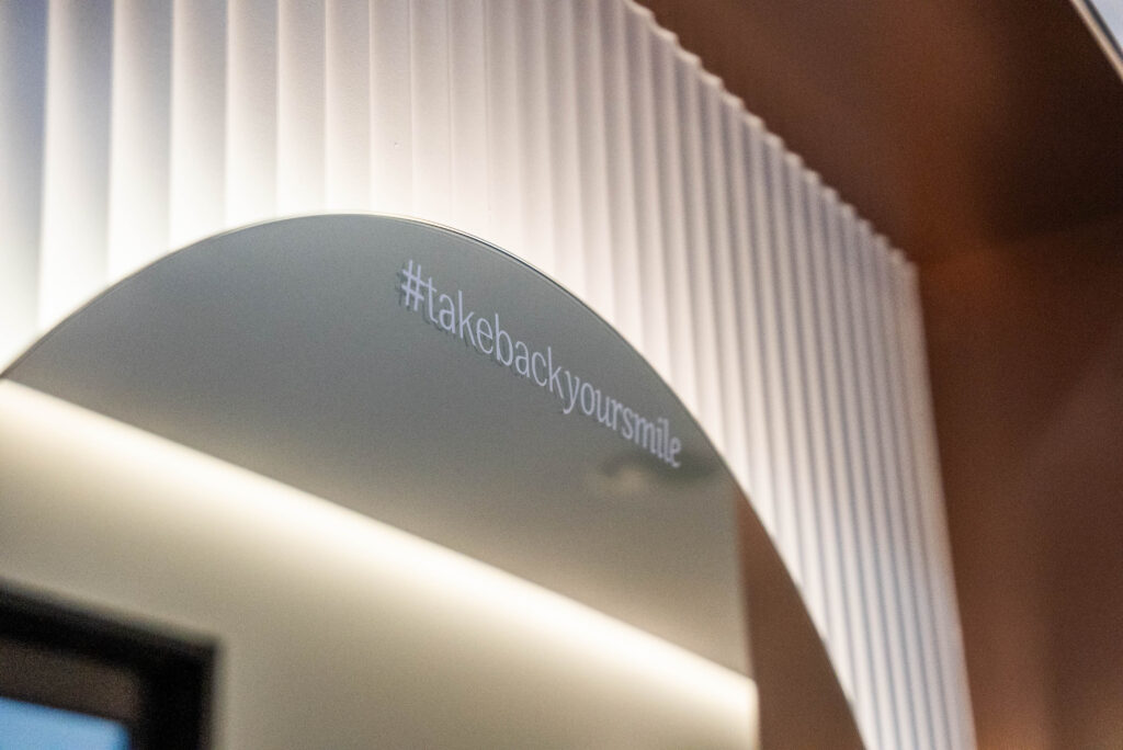 Close-up of illuminated feature mirror and architectural lighting highlighting curved wall detailing