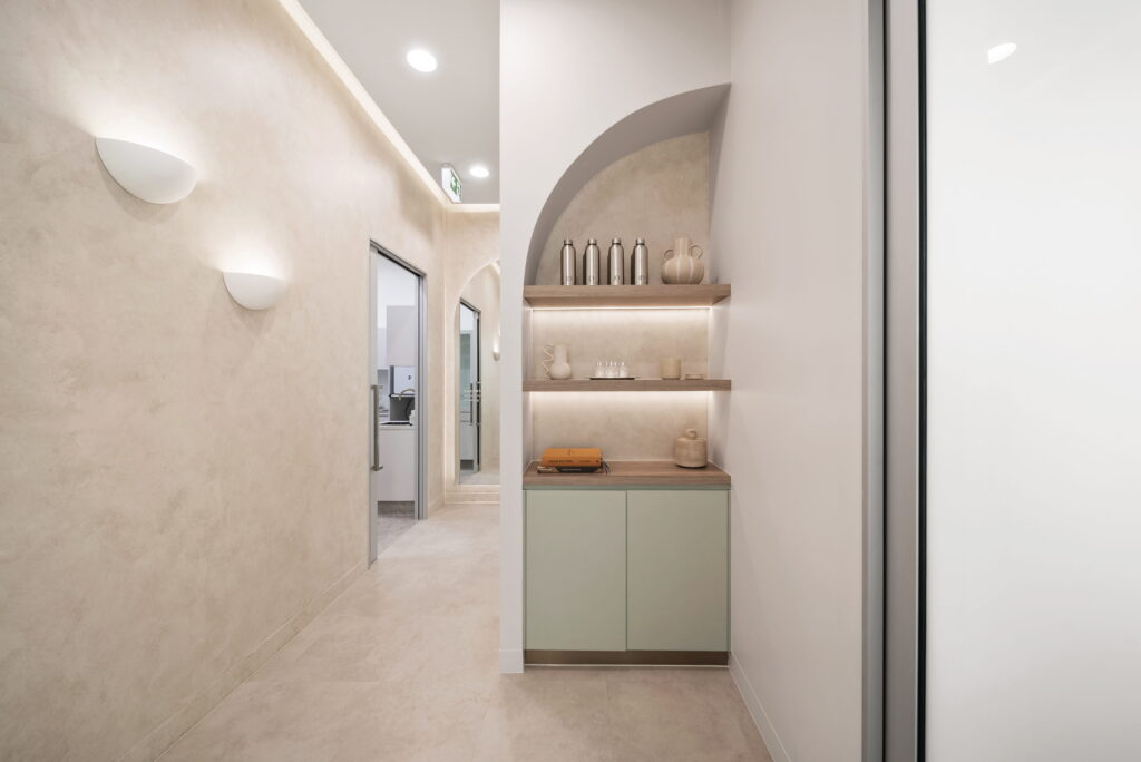 Dental clinic corridor with integrated shelving, feature lighting and softly illuminated architectural details