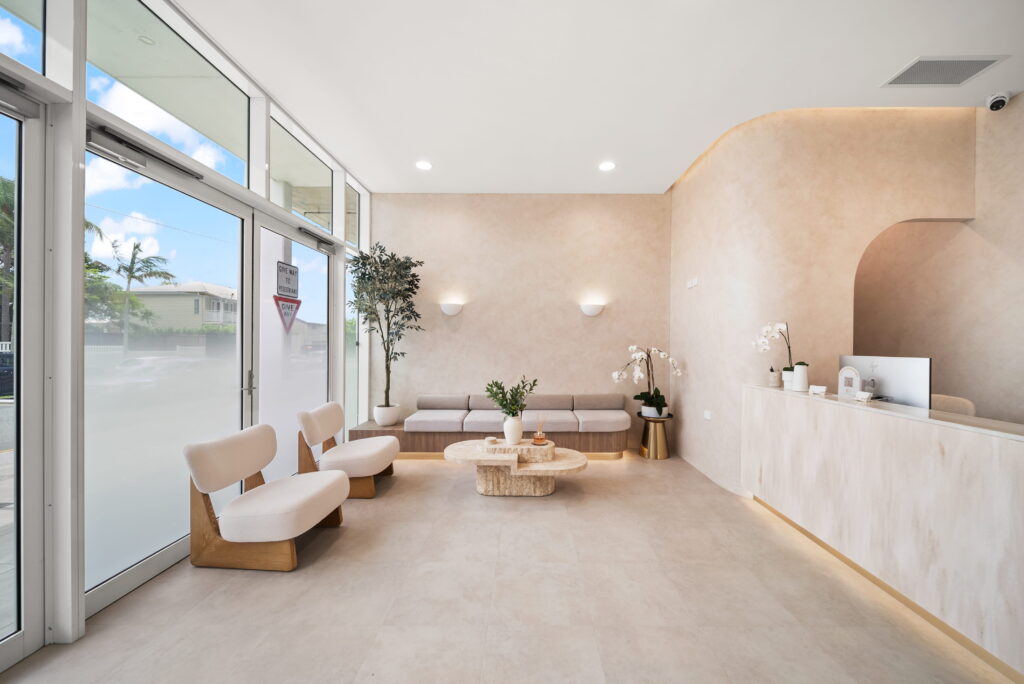 Dental clinic waiting area with natural daylight, warm wall lighting and minimalist reception design