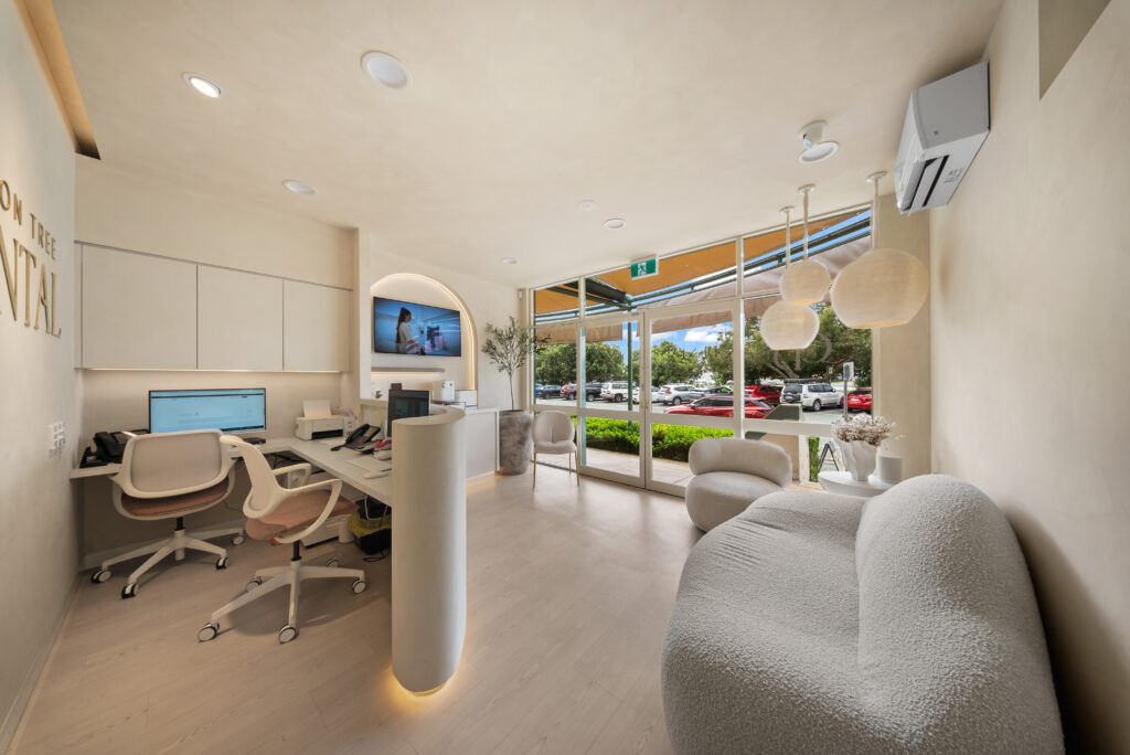 Dental reception featuring warm ambient lighting, large windows and a welcoming waiting area