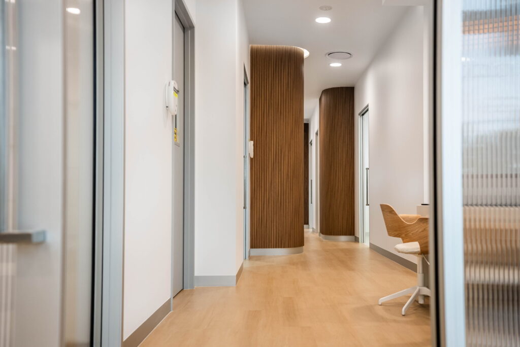 Healthcare clinic corridor with wide walkways and clear access between consulting and treatment rooms