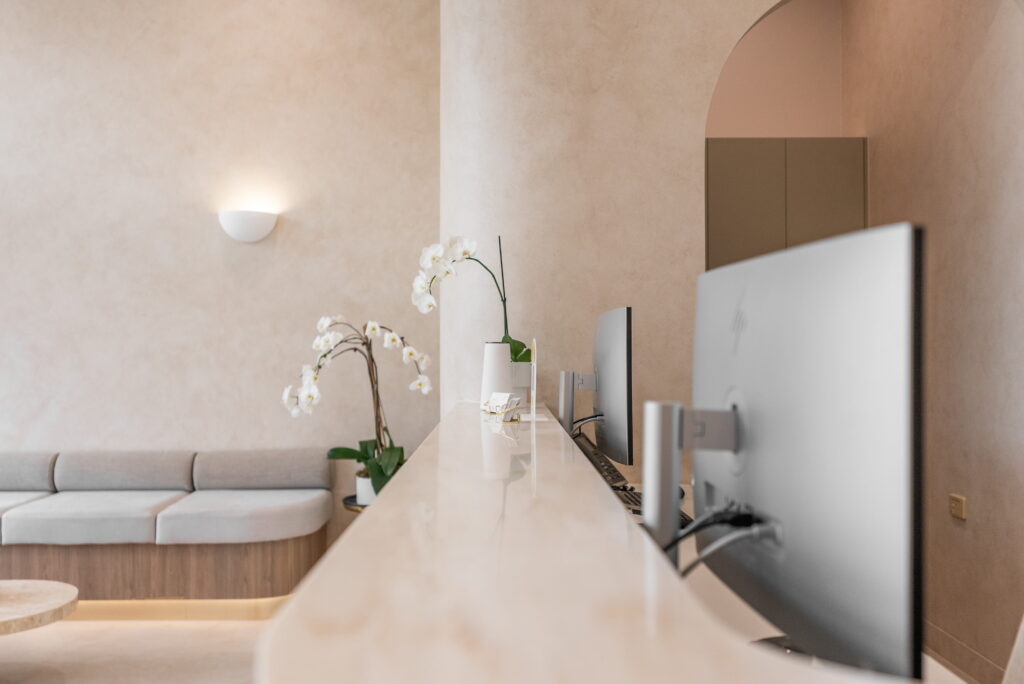 Reception counter in a modern dental clinic with warm architectural lighting and contemporary finishes