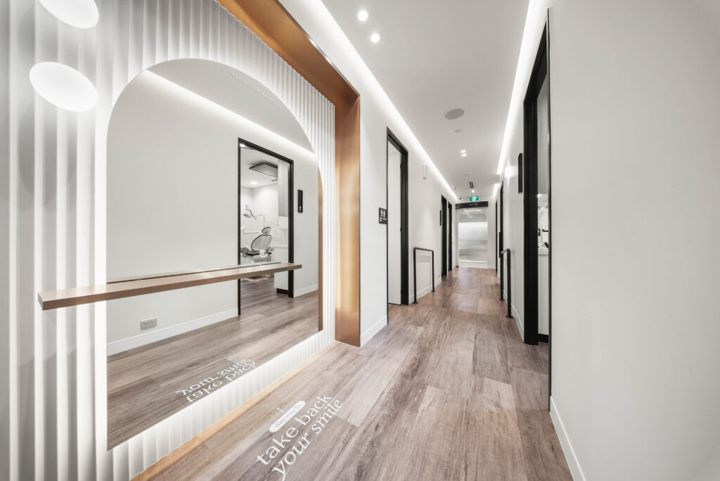 Wide healthcare corridor with accessible doorways and clear circulation supporting patient movement and clinical workflow.