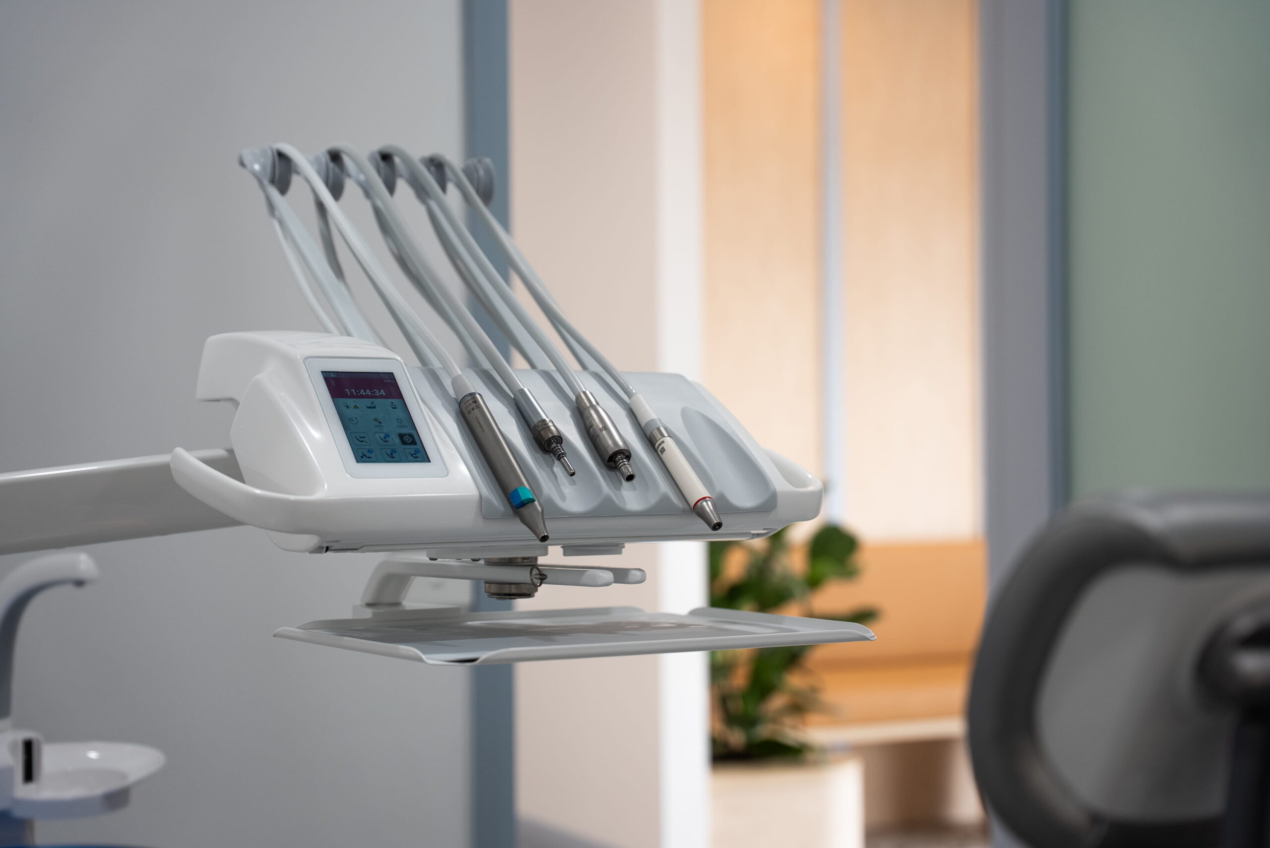 Close-up of dental instruments and handpieces positioned beside a patient chair in a treatment room