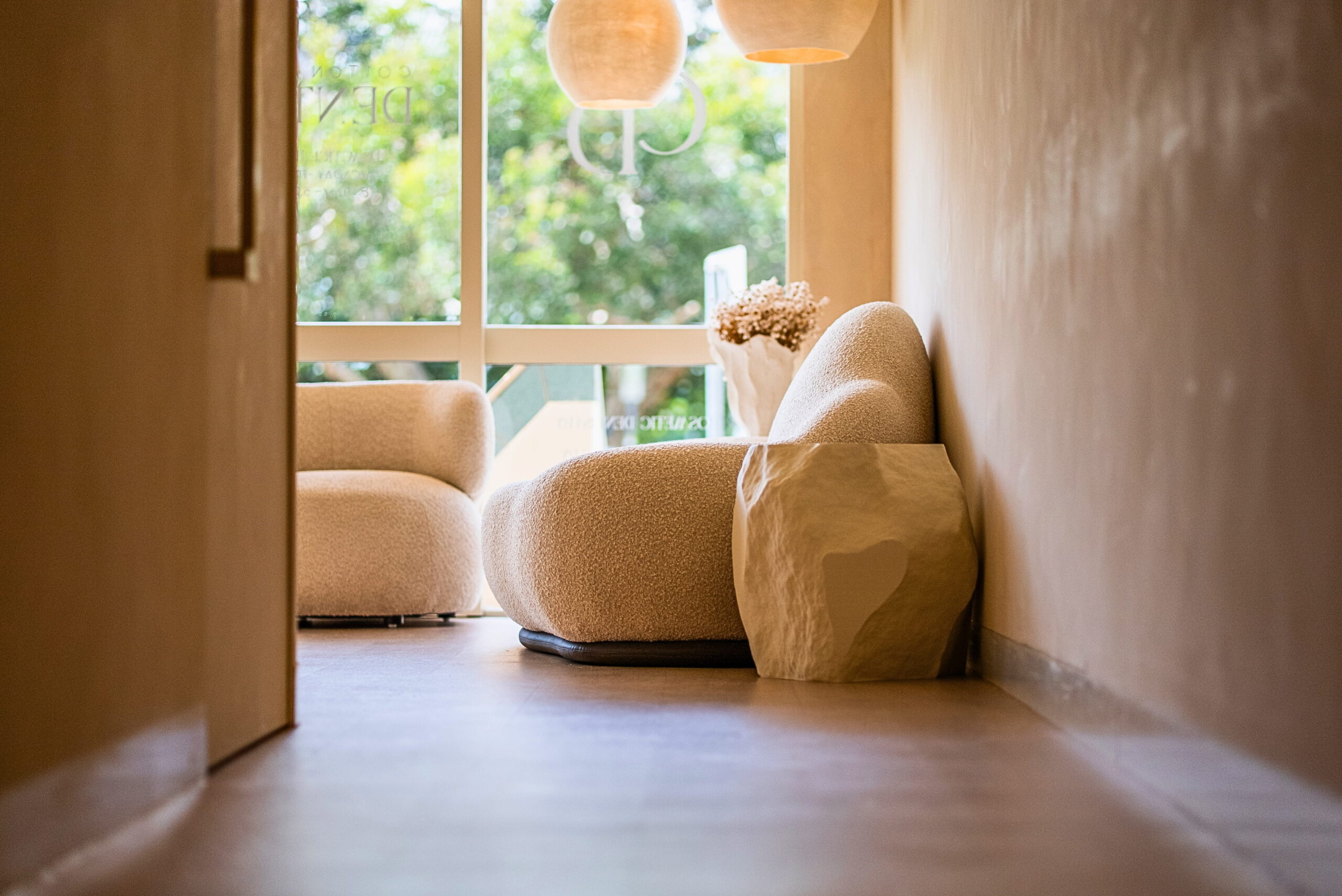 Quiet clinic waiting area with lounge seating beside a window.
